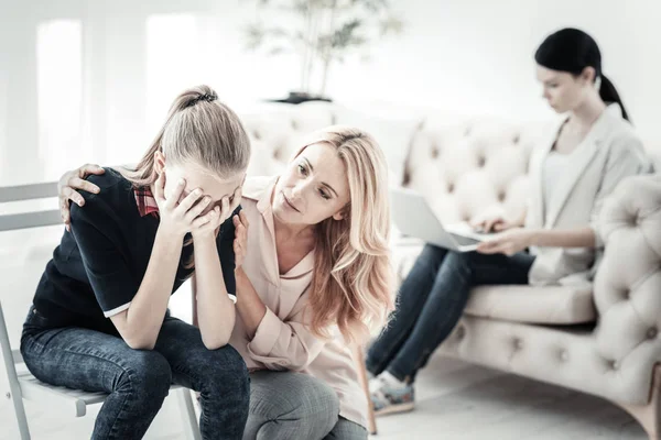 Attente mooie moeder zitten en ontroerend aan dochter. — Stockfoto