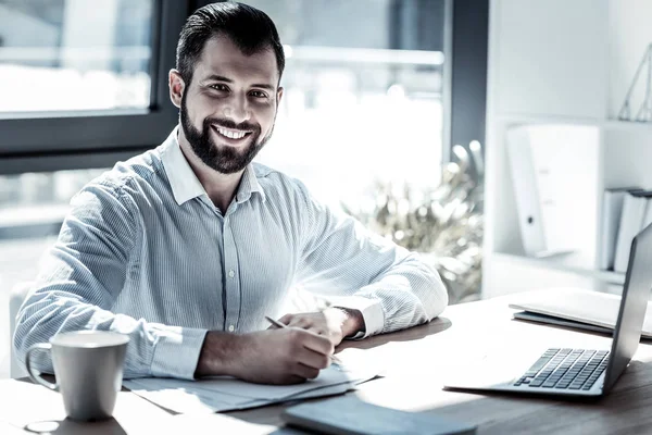 Hombre ocupado satisfecho trabajando y sonriendo . — Foto de Stock