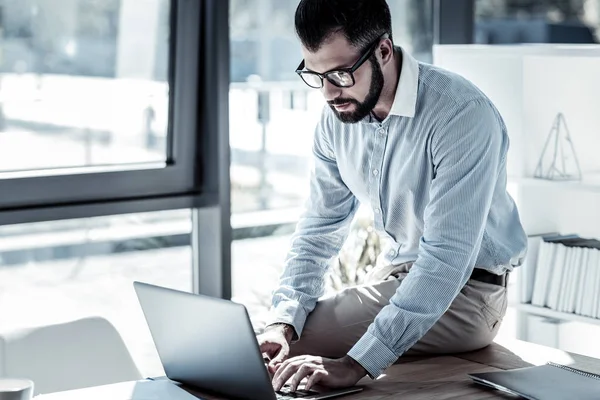 Konzentrierter Beschäftigter sitzt und bedient seinen Laptop. — Stockfoto