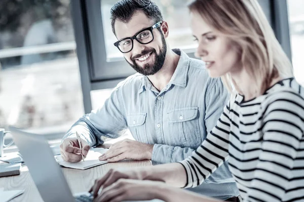 Joyful glasögonprydd man skriva och leende. — Stockfoto