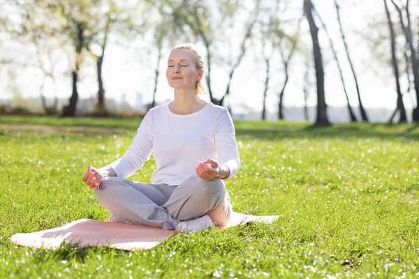 Mulher idosa agradável meditando — Fotografia de Stock