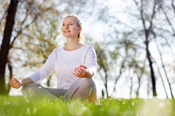 Joyeux enchanté femme assise dans l'herbe — Photo