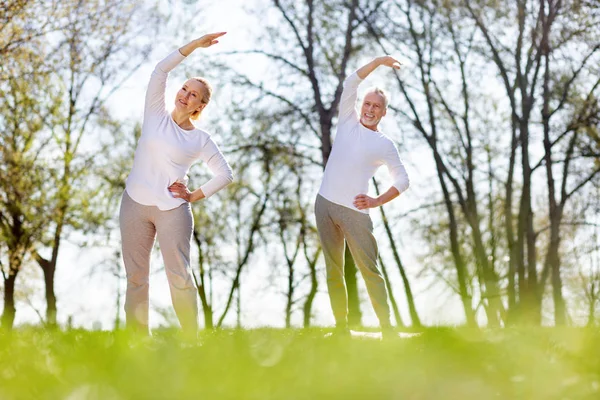 Personas mayores positivas haciendo ejercicio — Foto de Stock