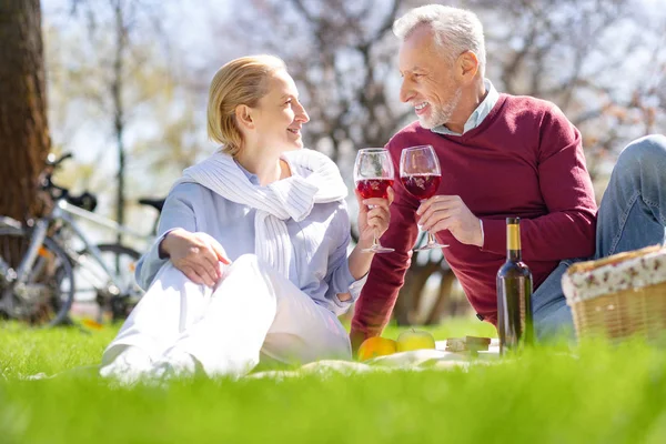 Delighted aged couple clinking glasses — Stock Photo, Image