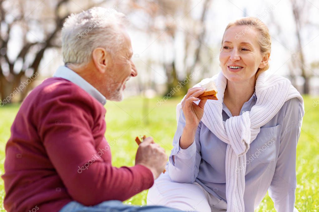 Joyful nice woman eating a sandwich