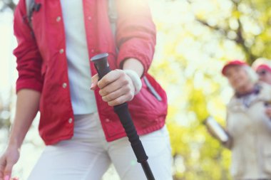 Bir sopa yürüyüş için kullanan atletik kadın