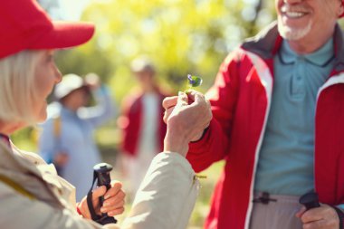 Gülümseyen adam bir kadın için bir çiçek veriyor