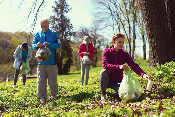 Equipo inspirado recogiendo basura en el bosque — Foto de Stock