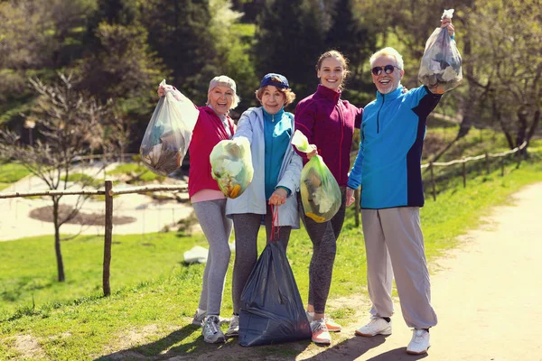 Χαρούμενα εθελοντές κρατώντας πακέτα με σκουπίδια — Φωτογραφία Αρχείου