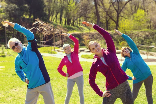 Pessoas sorrindo fazendo exercícios no parque — Fotografia de Stock