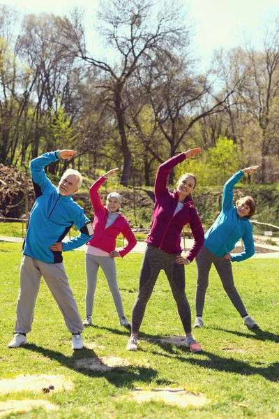 Pessoas inspiradas fazendo exercícios no parque — Fotografia de Stock