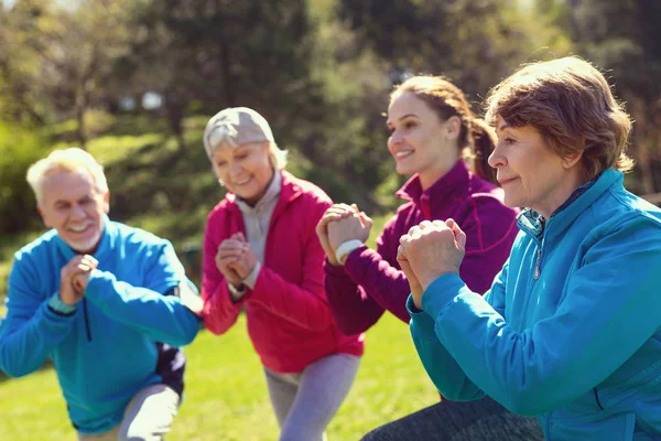 Mulher velha feliz exercitando com seus amigos — Fotografia de Stock