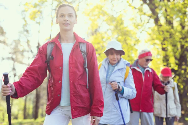 Joyful young woman hiking with her relatives — Stock Photo, Image
