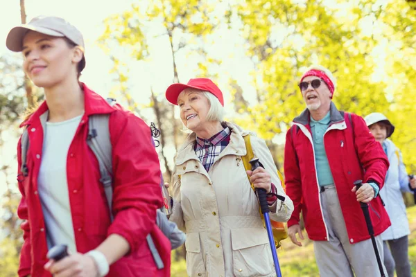 Delighted old lady hiking with her friends — Stock Photo, Image