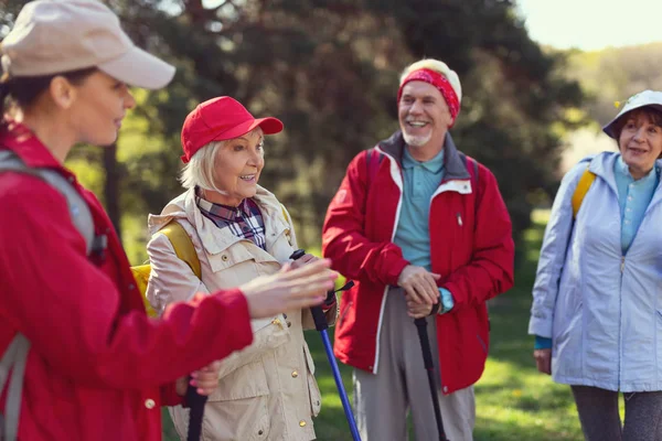 Happy aged woman talking with other hikers — Stock Photo, Image