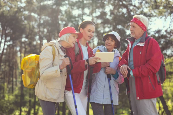 Cheerful hikers looking at the tablet for information — Stock Photo, Image