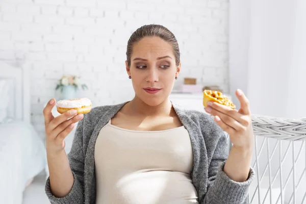 Töprengő terhes nő francia péksütemények kiválasztása — Stock Fotó