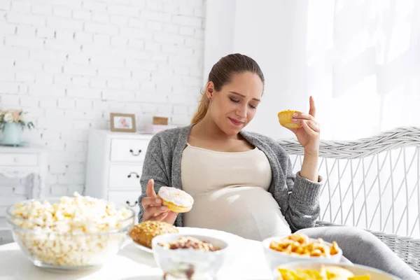 Vonzó terhes nő döntésnél sütemények — Stock Fotó