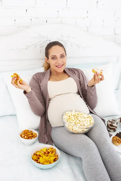 Joviale Schwangere schluckt Junk Food — Stockfoto