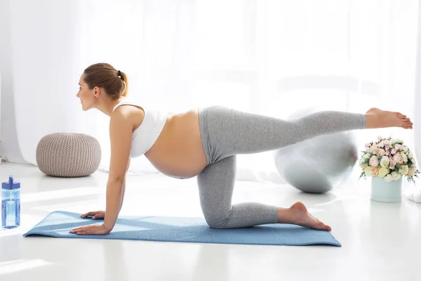 Сосредоточенная беременная женщина узнает о пренатальной йоге — стоковое фото