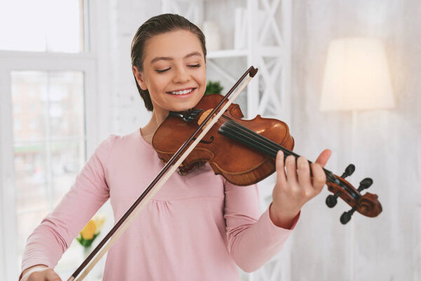Portrait of charming musician that looking at instrument