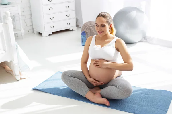 Cheerful pregnant woman revealing balance — Stock Photo, Image