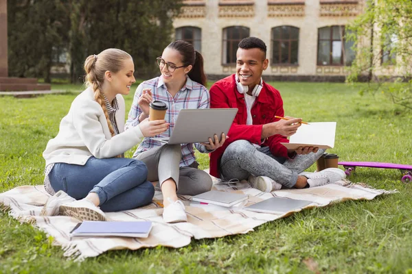 Трио умных студентов готовятся к международному экзамену в парке — стоковое фото