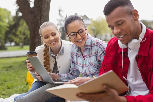 Young fellow sharing his excellent notes with his friends — Stock Photo, Image