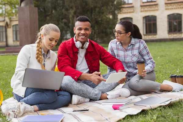 Estudante bonito sorrindo amplamente passar tempo livre com colegas de grupo — Fotografia de Stock