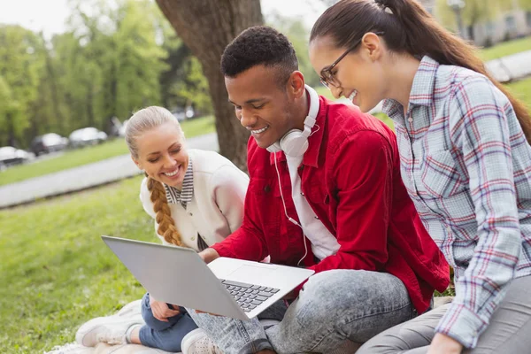 Trois étudiants discutent via skype avec leur ami — Photo