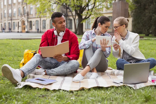 Três estudantes discutindo eventos atuais do mundo — Fotografia de Stock