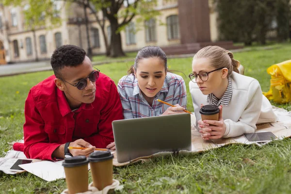 Tres estudiantes inteligentes se preparan para la prueba de idiomas juntos — Foto de Stock