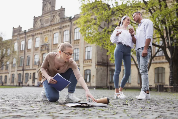 Estudiante agotada recogiendo sus cuadernos del suelo — Foto de Stock