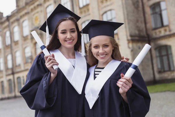 Két nővér, mosolyogva diplomák megszerzésével — Stock Fotó