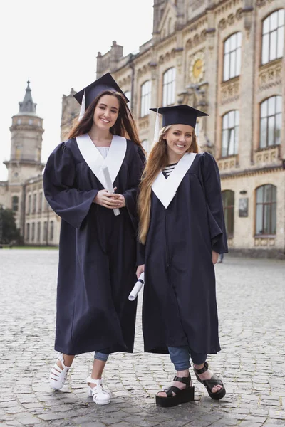 İki kız kardeş diploma aldıktan sonra memnun hissediyorum