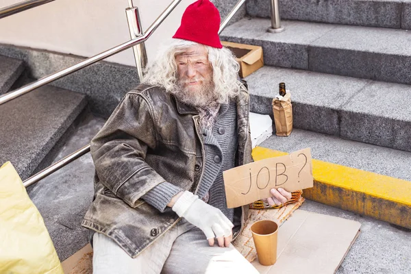 Aged homeless man holding a job sign — Stock Photo, Image