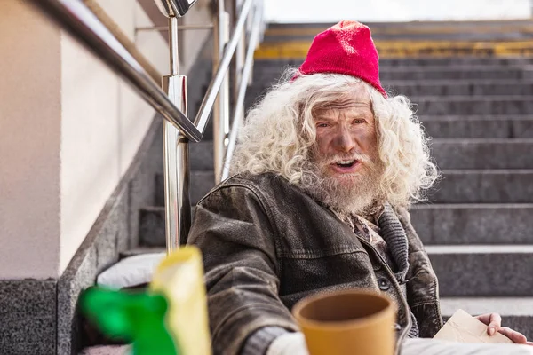 Cheerless homeless man sitting on the street — Stock Photo, Image