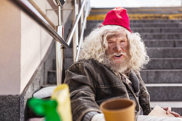 Cheerless homeless man sitting on the street