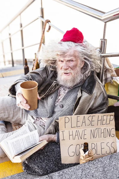 Merdivenlerde oturan depresif evsiz adam