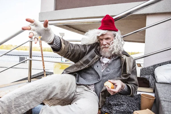 Mutsuz yaşlı adam elini germe