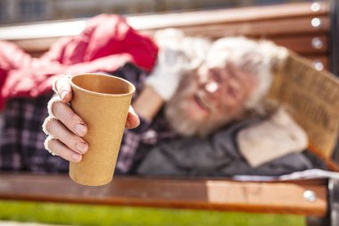 Seçici odak para bağış için bir fincan