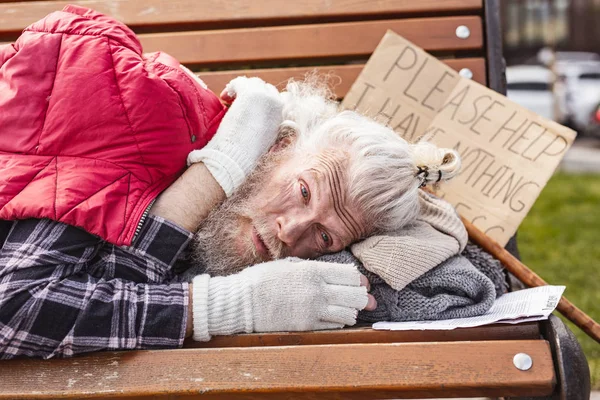 Homem idoso deprimido deitado no banco — Fotografia de Stock