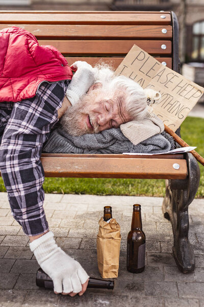 Tired drunk man sleeping on the bench