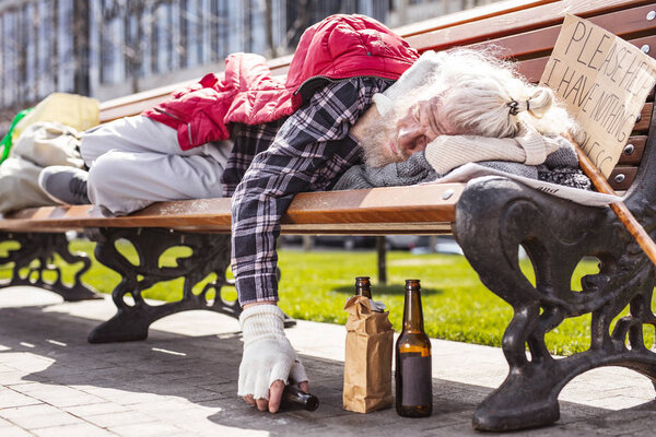 Aged drunk man holding an empty bottle