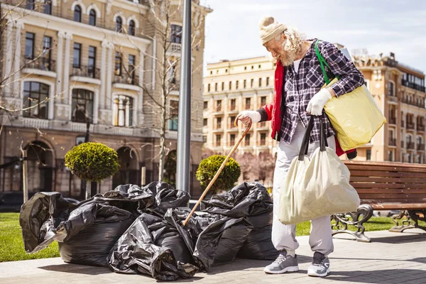 Depressiver Obdachloser schaut durch den Müll — Stockfoto