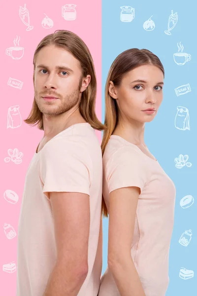 Couple of confectioners wearing casual clothes and standing back to back — Stock Photo, Image