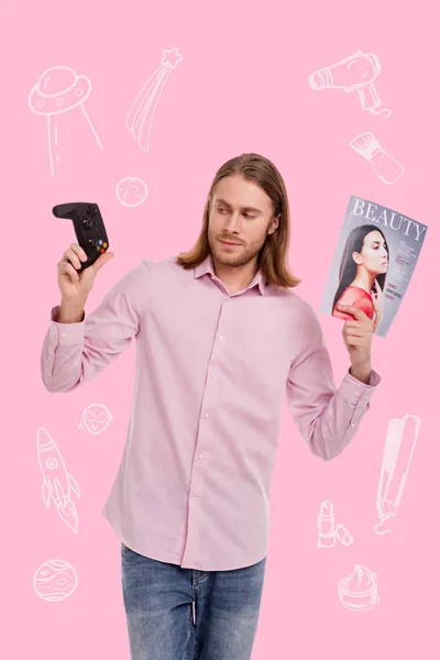 Внимательный человек смотрит на игровую консоль, держа в руках журнал — стоковое фото