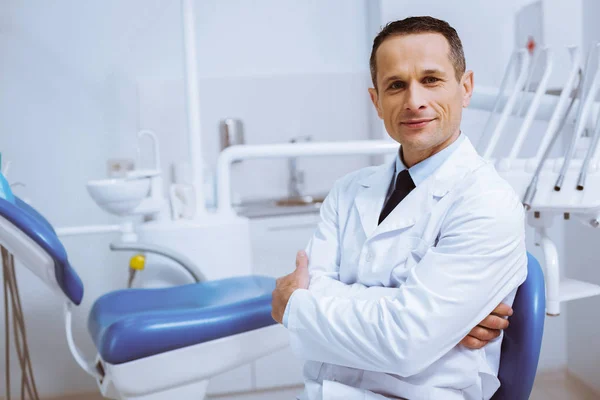 Confident dentist sitting in his cabinet — Stock Photo, Image