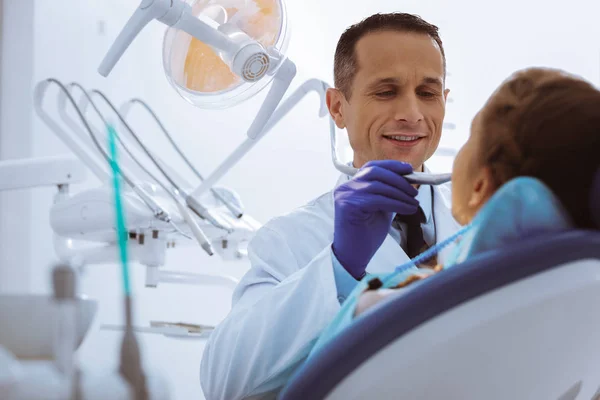 Dentista atento fazendo seu trabalho com prazer — Fotografia de Stock