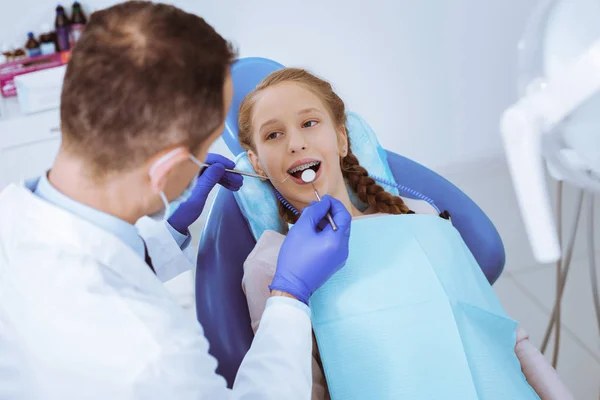 Positivo ragazza felice fissando il suo stomatologo — Foto Stock